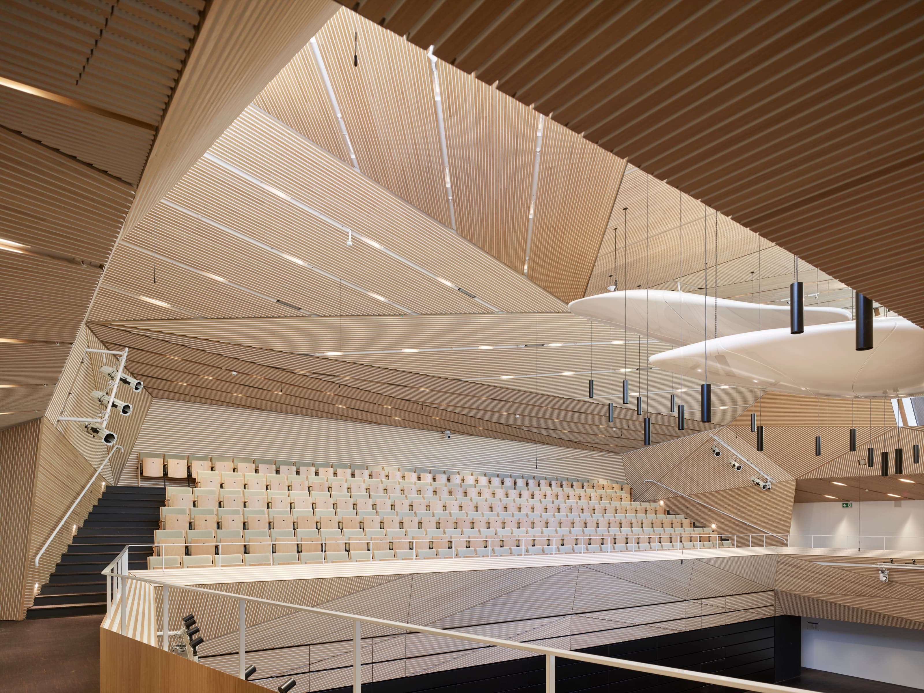 Stepped golden timber acoustic panelling inside the Andermatt concert hall